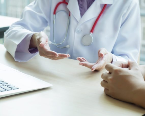Doctor and patient are discussing something, just hands at the t Doctor and patient are discussing something, just hands at the table